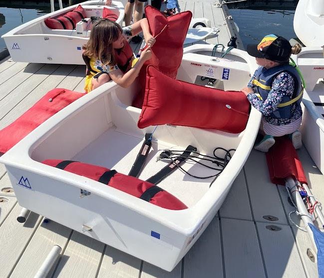 Two kids working together on a sailing boat